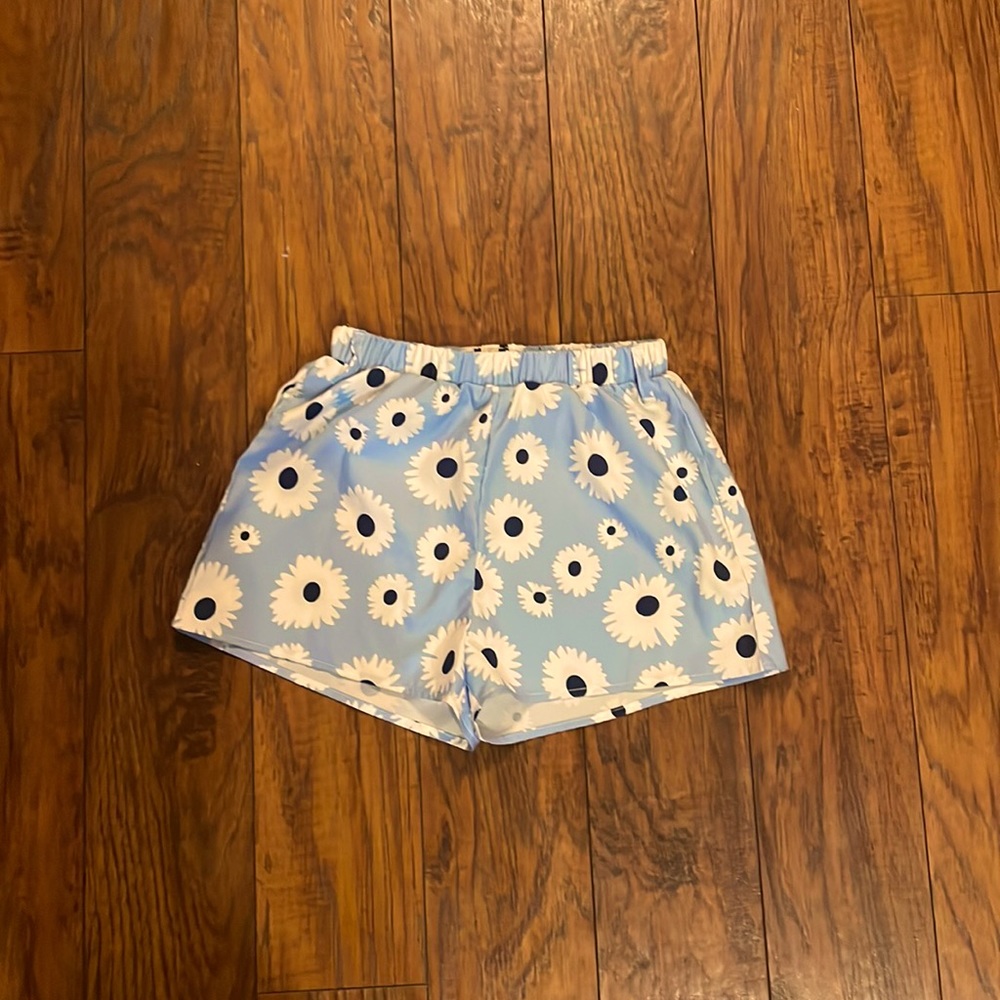 A pair of blue shorts with flowers and a belt size extra small
